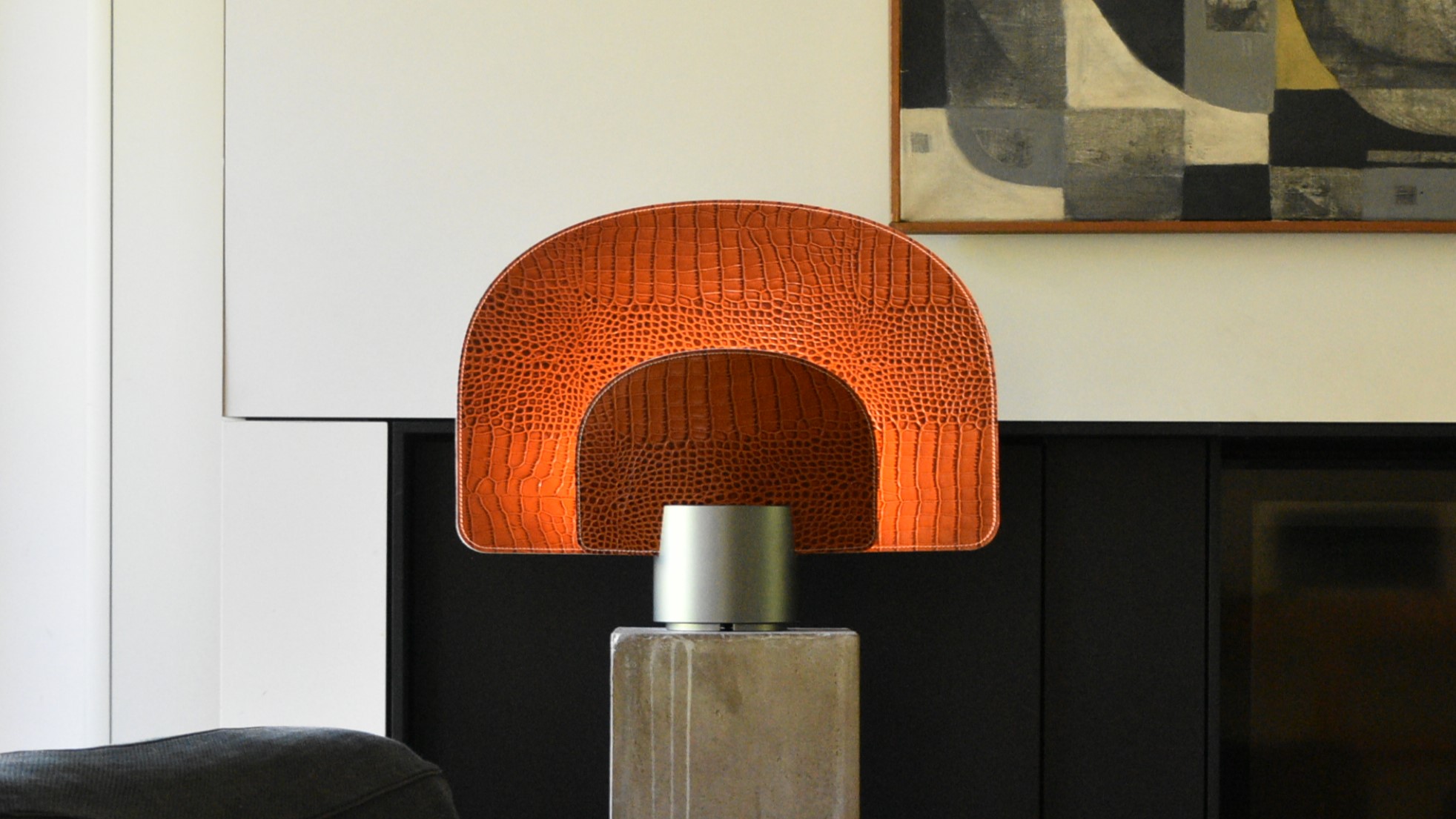 Duocurve modular leather table lamp glowing warmly in a dark interior — designed by Loïc Corthals, Belgium